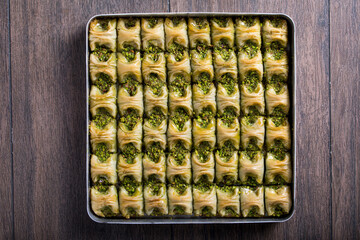 baklava whit pistachio in tray on the wooden table