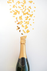 a bottle of champagne and confetti on a white background, the concept of the holiday