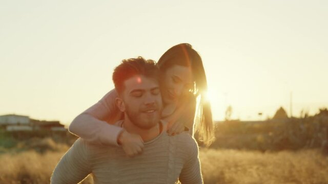 Coppia di ragazza e ragazzo si abbracciano al tramonto in un parco per San Valentino