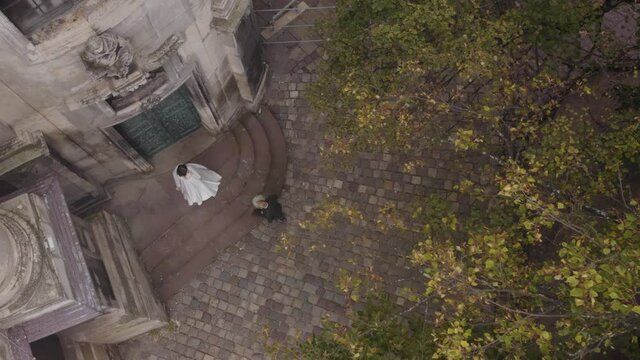 Newlyweds aerial drone view. Happy lovely bride meeting groom with bouquet in park. First meeting. Happy wedding couple family. Romantic love of man and woman. Bride in wedding dress. Bridegroom