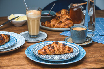 croissants with a cup of coffee on a wooden table.