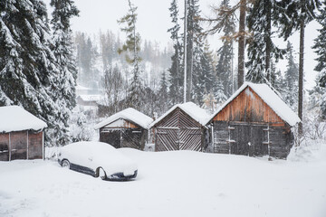 Winter landscape - wooden houses and car under white snow