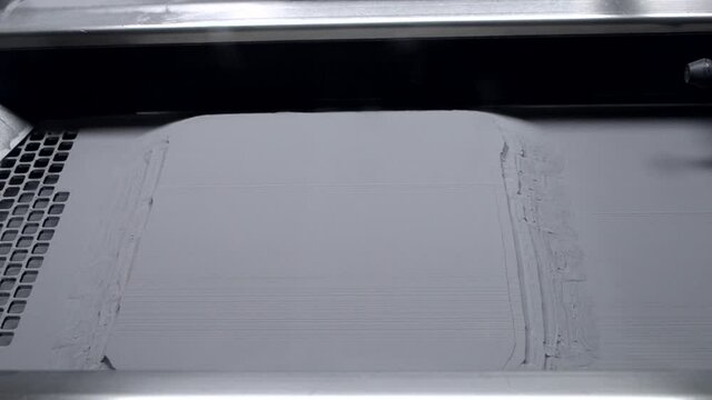 3D printer for metal inside. Platform with printed models and crumbling powder lifted up in working chamber. Laser sintering machine for metal. New modern progressive additive 3D printing technology