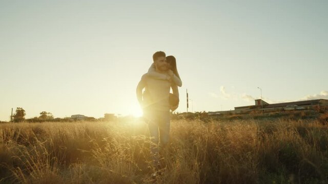 Coppia di ragazza e ragazzo si abbracciano al tramonto in un parco per San Valentino