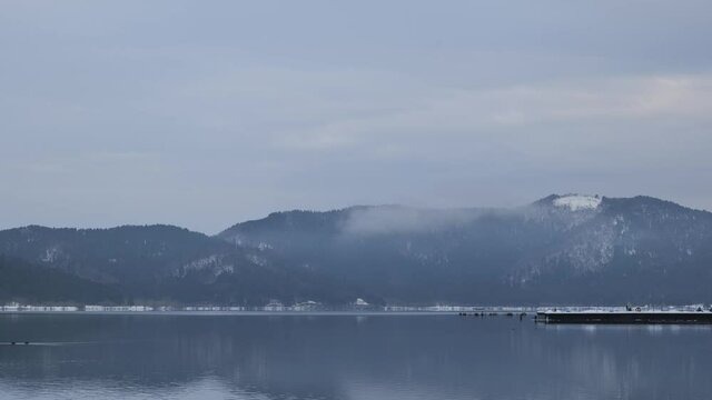 Video of Lake Yogo, Shiga Prefecture, in the dead of winter, with the surrounding area covered in white snow, a frozen landscape.