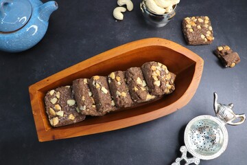 Homemade cashew nuts and chocolate chips cookies. Best tea time healthy baked biscuits in a wooden boat shaped plate. Christmas concept. High Tea concept. Copy space.