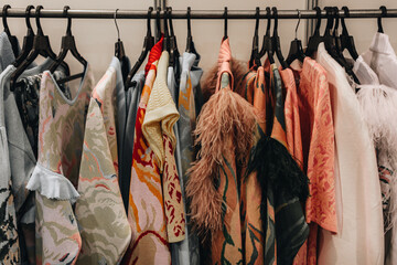 Fashion outfits hanging in a row at the backstage 