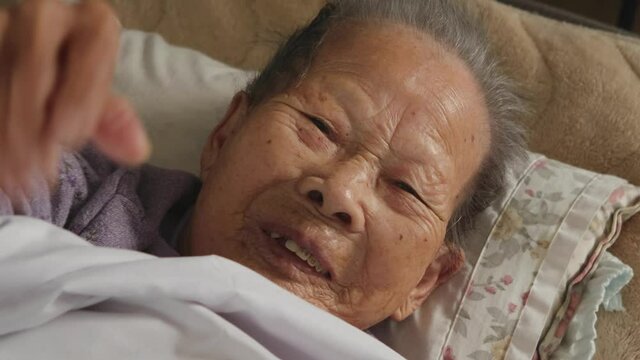 見舞客に手を振って歓迎するおばあちゃん