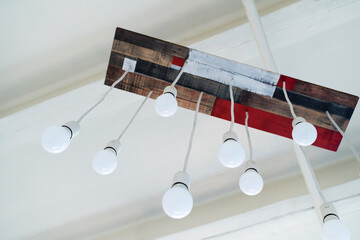 Homemade chandelier made of wooden platform and LED bulbs. Ideas for making lighting fixtures from...
