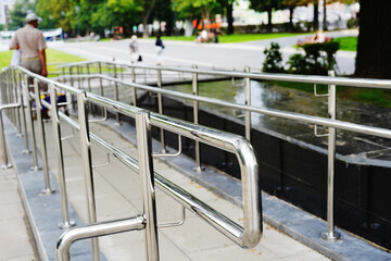 Chrome-plated railings installed on a city street. Foreground. Selective focus