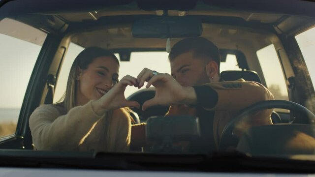 Coppia ragazzo e ragazza trascorrono la festa di San Valentino insieme nella macchina fuoristrada in campagna al tramonto