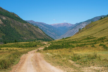Dirt gravel mountain road through the high Altai plateau, Siberia, Russa.