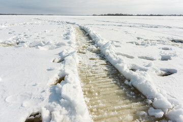 Snowmobile trail on the frozen river. Selective focus