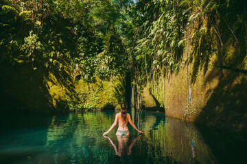 Natural pool with rocks, young woman and tropical plans at Bali.