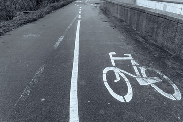 Obraz premium Bicycle lane. Bicycle lane sign on asphalt. Dirty sidewalk with white bike path sign