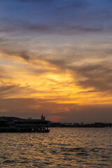Obraz premium Beautiful sunset over the ocean at Sriracha town in Chonburi, Thailand showing colorful sky and dramatic cloud formations