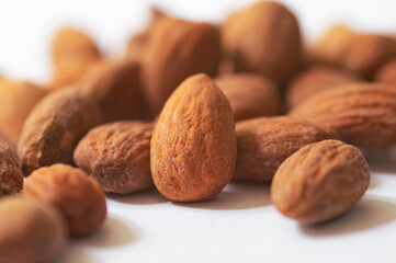 Heap of almond nuts isolated on white background