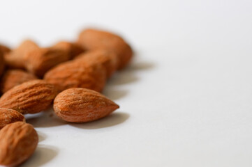 Heap of almond nuts isolated on white background