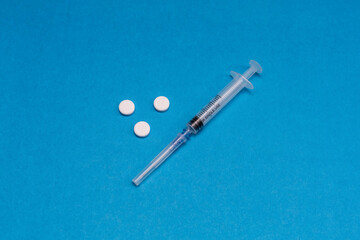 Disposable syringe on a blue background. A syringe for injection.