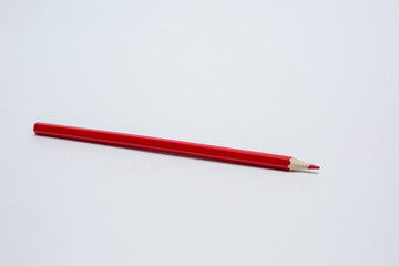 Red pencil on a white background.