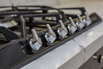 Metal handles for regulating the temperature of the gas stove in the kitchen. Selective focusing.