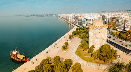 Aerial panoramic view of the main symbol of Thessaloniki city - the White Tower with boat tour ship...