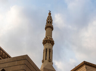 Obraz premium Shot of a minaret with cloudy sky on background. Religion