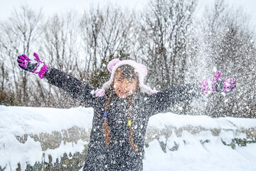 Happy child is having fun playing in the snow