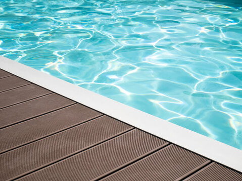 Tropical floor swimming pool with clean water, outdoor swimming pool edge wooden pavement