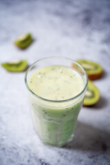 Kiwi banana smoothie in a glass ith kiwi slices