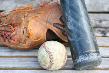 ベンチの上の野球ボールとグローブとバット