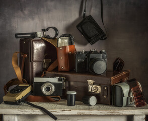 Old film cameras, photographic film, leather cases for photographic equipment. Old photographic equipment. Film photography nastalgia.