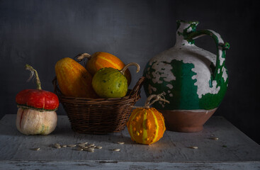 Ripe and tasty pumpkins on the table. Old, peeling, ceramic jug. Retro still life.