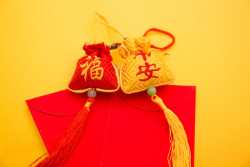 Lunar New Year decoration with lucky gold bar, lucky sacks, and red fish isolated on yellow . Tet Holiday.Translation of text appear in image: fortune good luck	