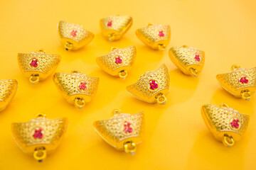 Lunar New Year decoration with lucky gold bar isolated on yellow . Tet Holiday.Translation of text appear in image: fortune good luck	
