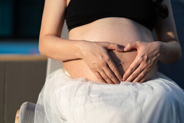 A prenency mother is hugging baby in womb - lovely family emotion concept photo. Healthcare and family people abstract, Selective focus.