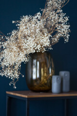 dried flowers stand in a transparent vase on the table