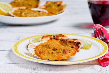 Baked scallop with béchamel sauce, prawns and ham. typical dish of Galicia (Spain)