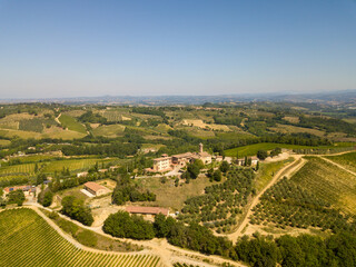 Fototapeta na wymiar Aerial/Drone Panorama of Tuscany landscape with vineyards and olive trees - With Montauto castle and San Gimignano - Italy 