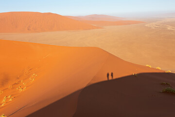 Fototapeta na wymiar Desert landscape with shadows of people, view of the dunes of Sossusvlei, Namibia