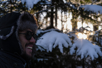 Latin American man with a big smile in a winter forest 