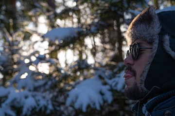 Latin American man in a winter forest ( tongue out) 