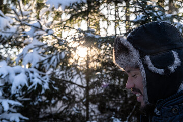 Man walking in a snowy forest (smiling) 