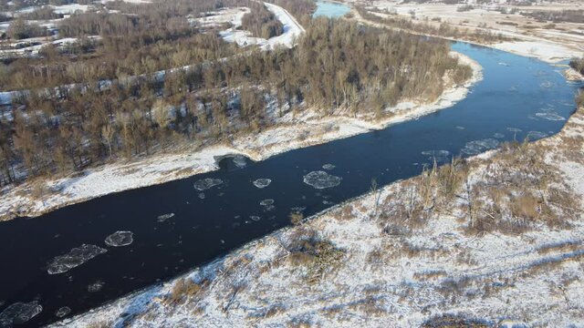 Flight over the river on a winter sunny day a moment after the water freezes.