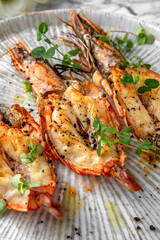 Grilled king prawns in a festive plate on a marble background. Restaurant banquet menu.