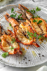 Grilled king prawns in a festive plate on a marble background. Restaurant banquet menu.
