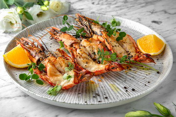 Grilled king prawns in a festive plate on a marble background. Restaurant banquet menu.