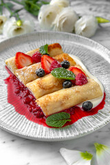 Pancakes or cheese cakes with condensed milk and berries in a festive plate on a marble background. Restaurant banquet menu.