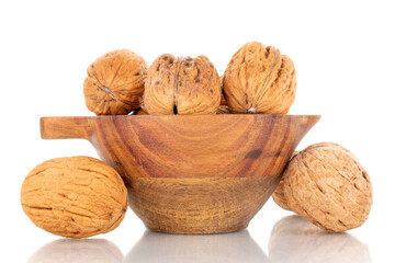 Several ripe delicious walnuts with a wooden dish, close-up, isolated on white.