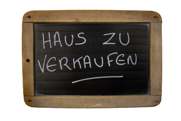 Schiefertafel mit deutscher Schrift darauf: Haus zu verkaufen
